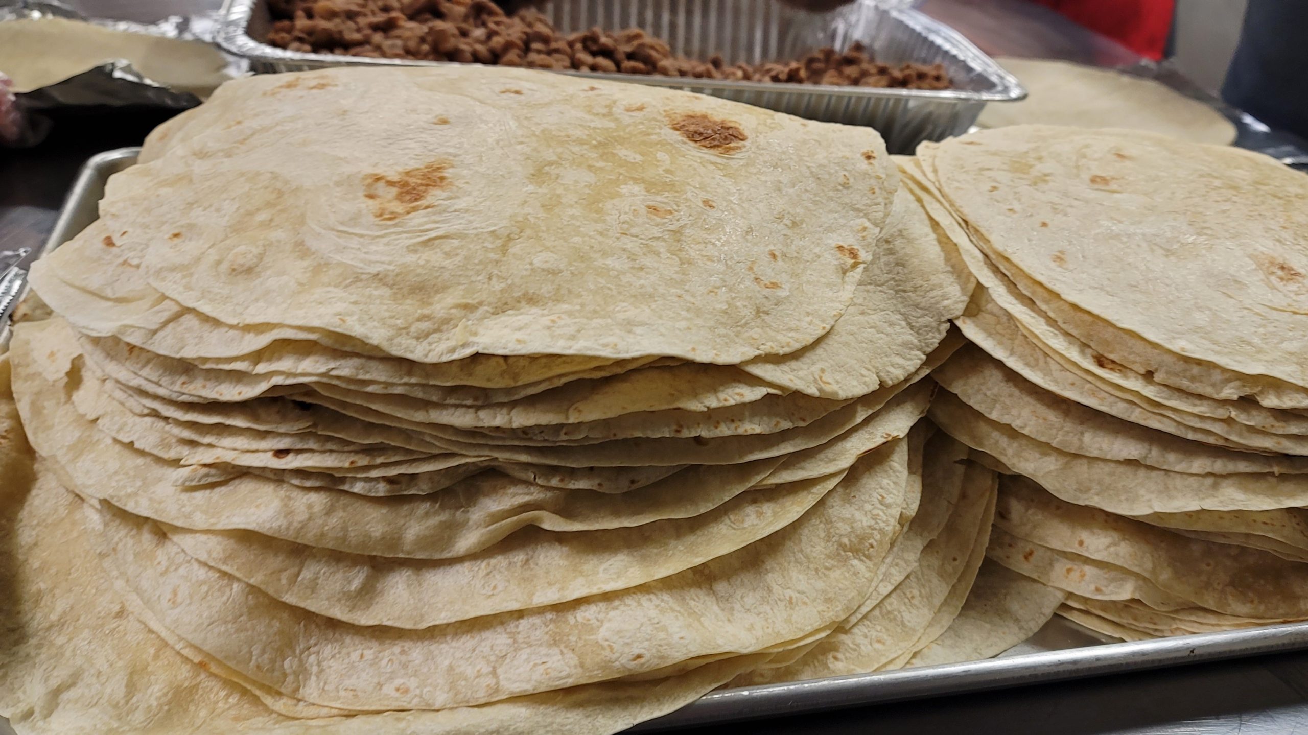 A tray stacked high with fresh flour tortillas